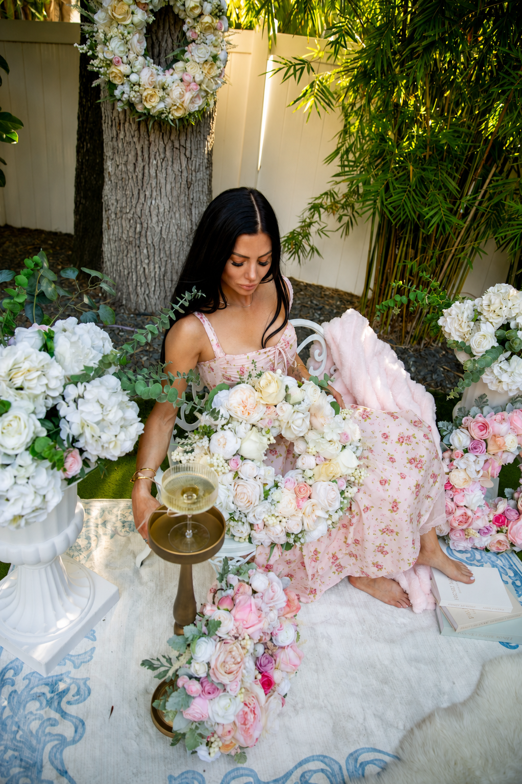 The Charming Stylist founder surrounded by luxury faux floral arrangements
