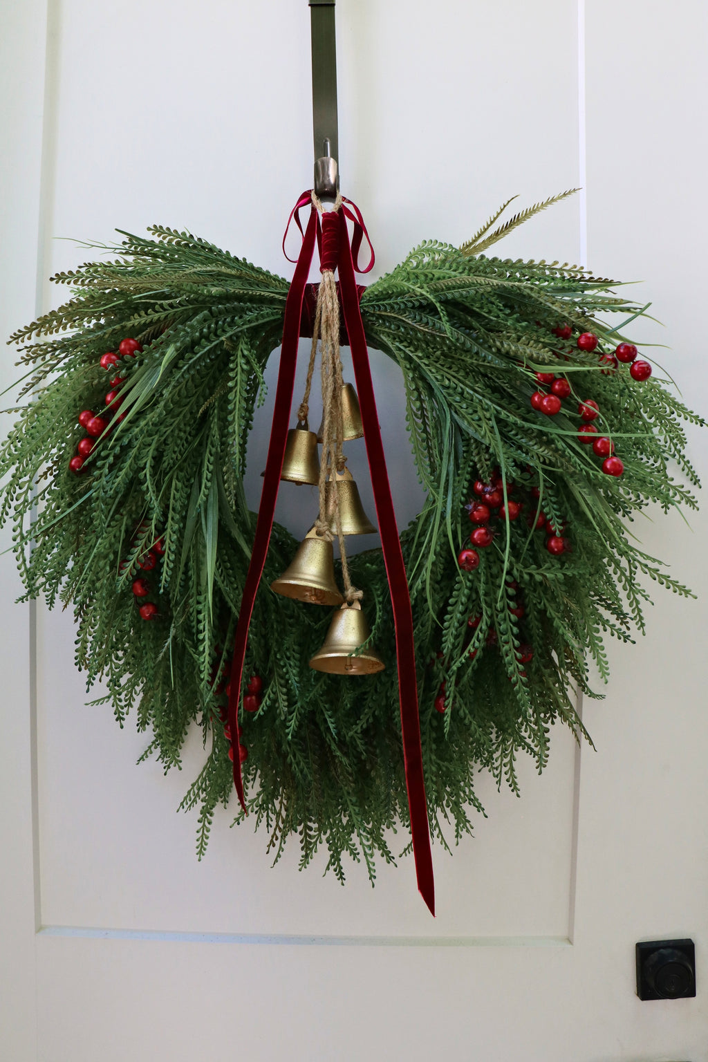 Cascading beaded-grass wreath with red berries, burgundy velvet ribbon and five hanging gold-tone bells.