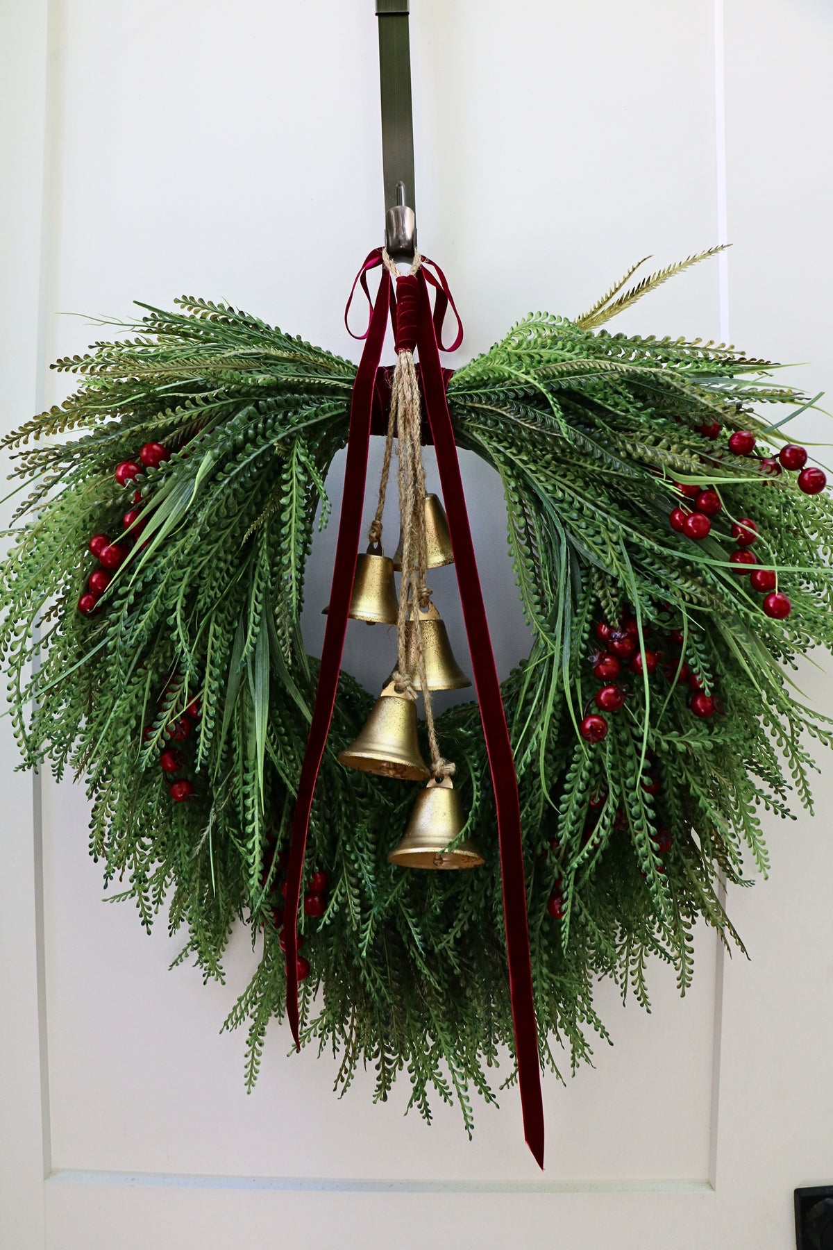 Cascading beaded-grass wreath with red berries, burgundy velvet ribbon and five hanging gold-tone bells.