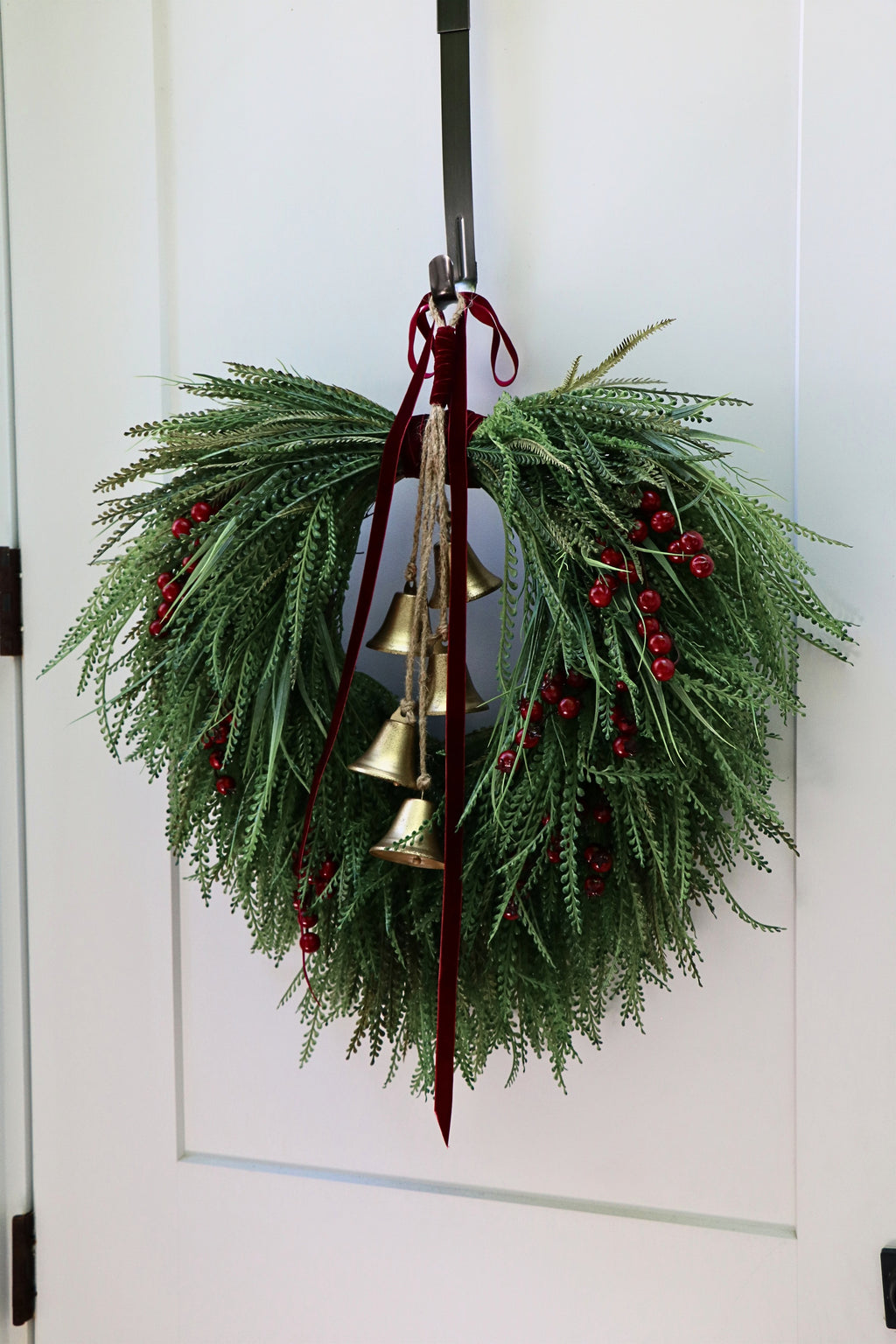 Cascading beaded-grass wreath with red berries, burgundy velvet ribbon and five hanging gold-tone bells.