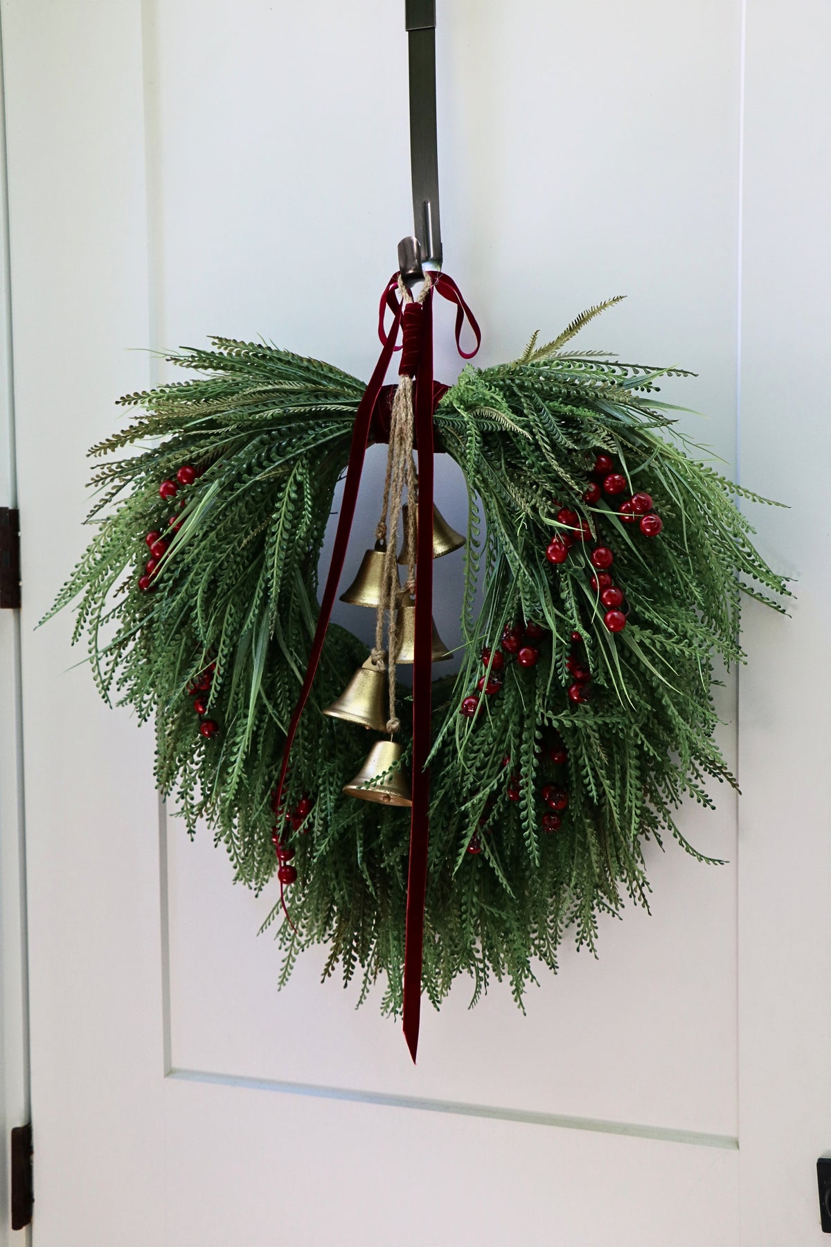 Cascading beaded-grass wreath with red berries, burgundy velvet ribbon and five hanging gold-tone bells.