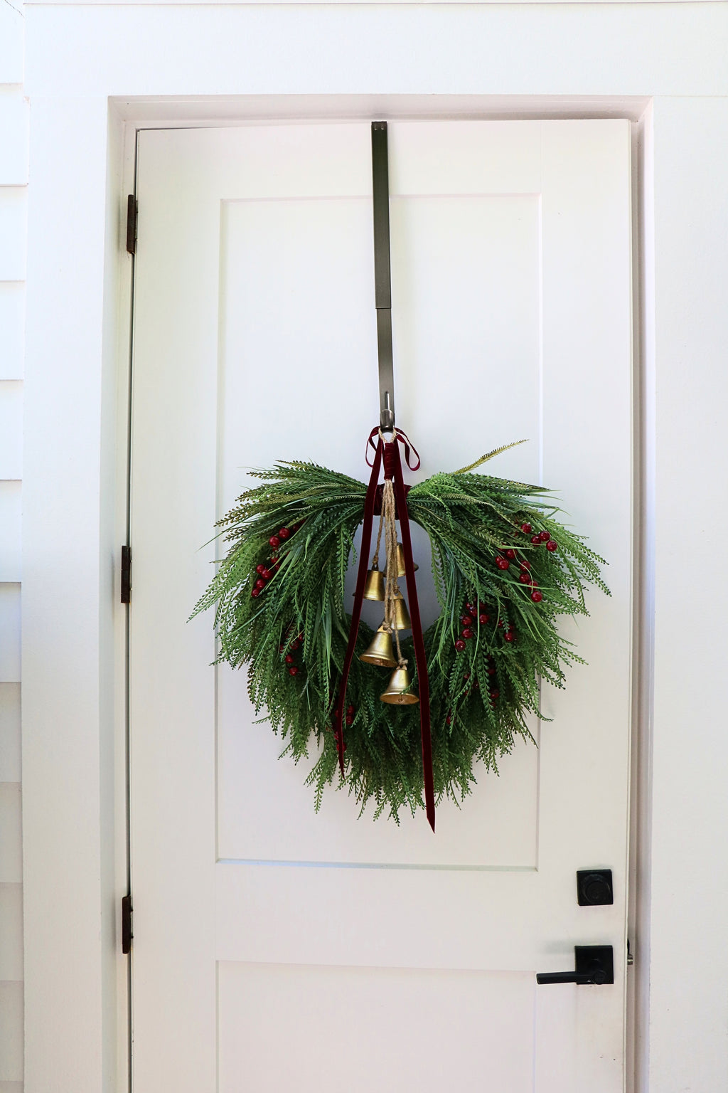 Cascading beaded-grass wreath with red berries, burgundy velvet ribbon and five hanging gold-tone bells.