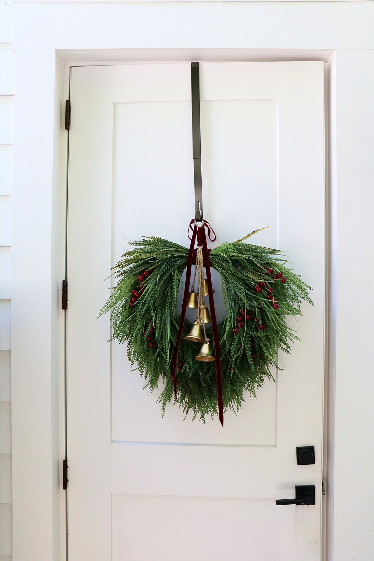 Cascading beaded-grass wreath with red berries, burgundy velvet ribbon and five hanging gold-tone bells.