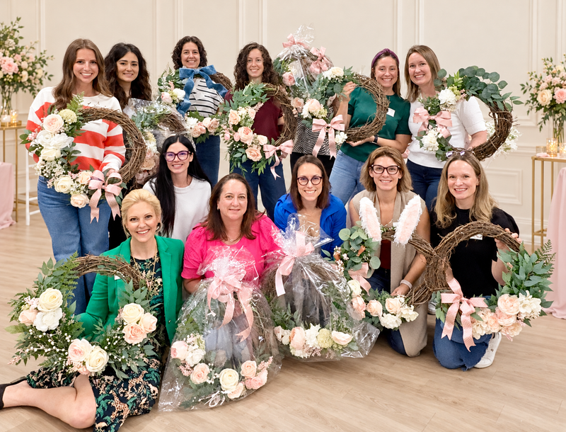 Workshop guests displaying their floral grapevine wreaths at a Seasonal Wreath Workshop.